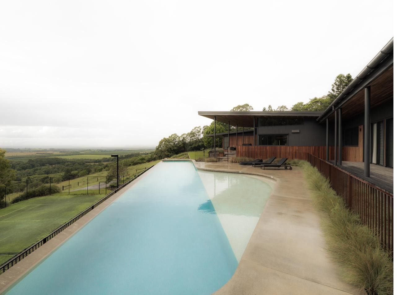 Infinity-edge pool along the residence with paddock views, Newrybar Residence